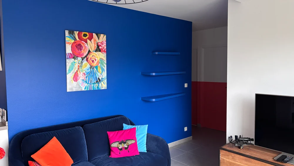 Salon au mur bleu — étagères et ambiance colorée